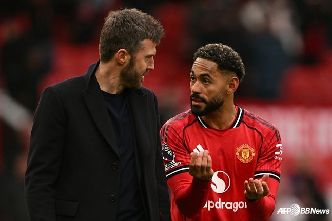 Manager Michael Carrick (left) is seen in conversation with Mateus Cunha. /AFPBBNews=NEWS1