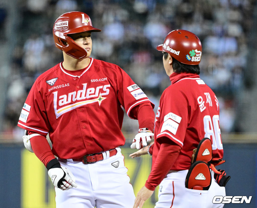 SSG's Kim Jae-hwan (left) celebrates with coach Yoon Jae-guk after hitting his second hit in the bottom of the fifth inning.