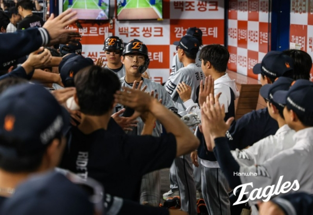 14日，韩华鹰队捕手许仁书（左）在与Kiwoom Heroes队的客场比赛中进球后，受到了队友们的欢迎。 =韩华鹰队。