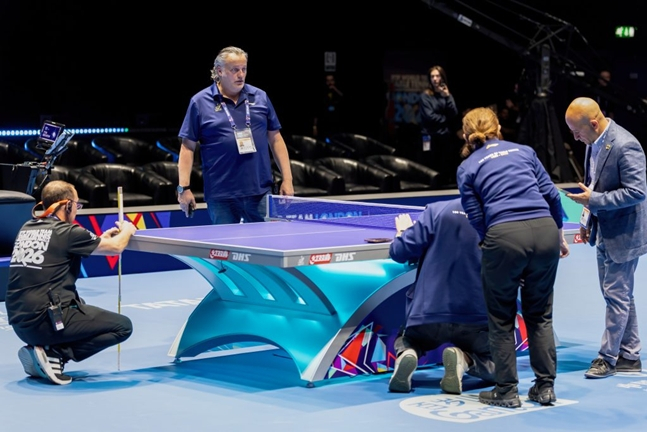 Organizing committee staff urgently repairing the table climbed on by Romanian players. /Photo=England Table Tennis Association