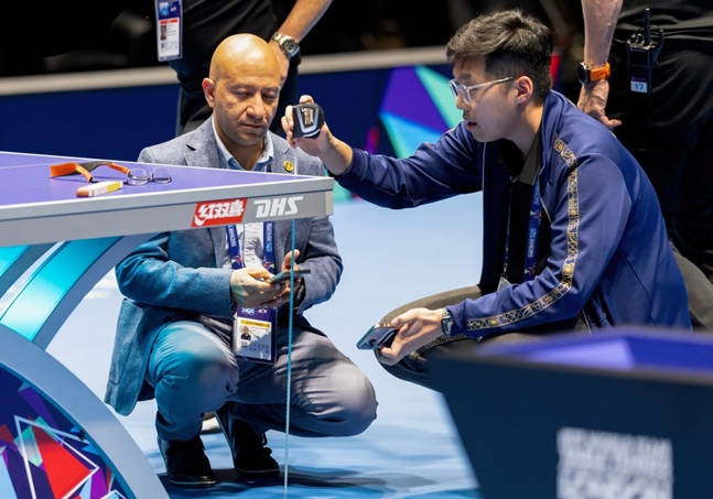 Organizing committee staff urgently repairing the table climbed on by Romanian players. /Photo=England Table Tennis Association