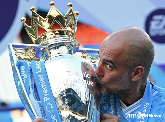 Manager Pep Guardiola kissing a trophy. /AFPBBNews=NEWS1
