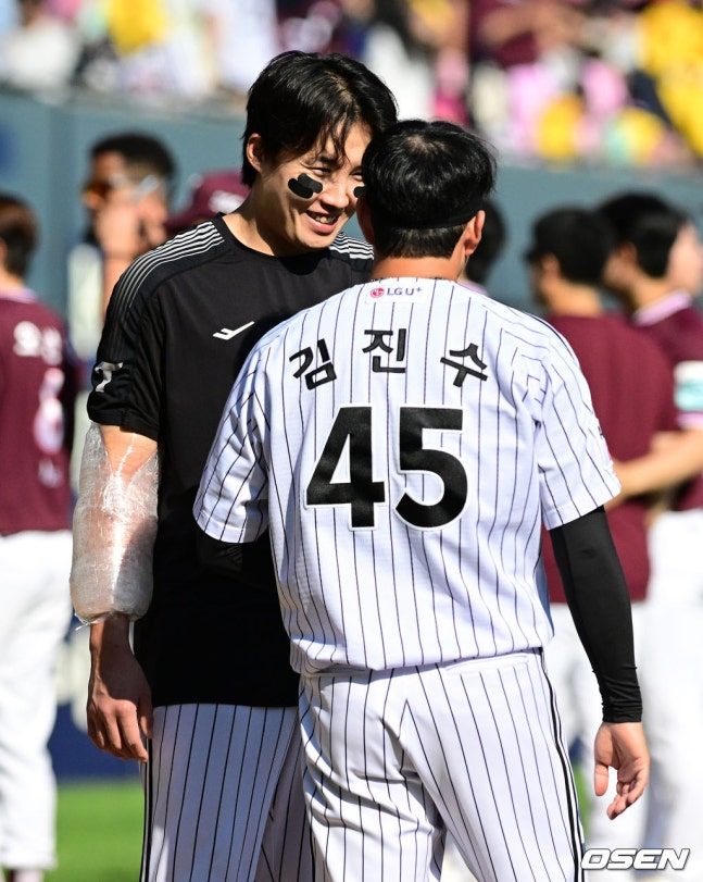 LG's Im Chan-kyu (left) smiles at Kim Jin-su after the 23rd victory over Kiwoom, thanking him for securing his fourth win.