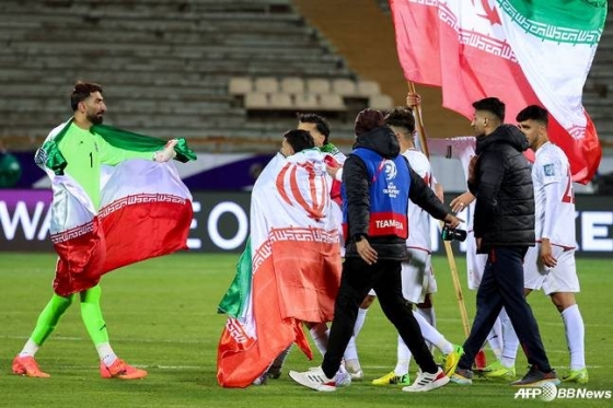 W杯進出が確定したイラン選手たちが国旗を身につけて喜んでいる。 /AFPBBNews=ニュース1