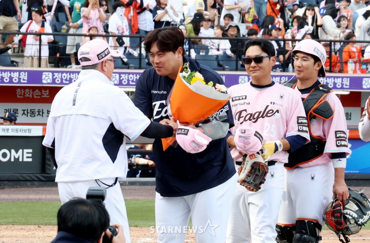 Ryu Hyun-jin de los Hanwha Eagles (segundo desde la izquierda) recibe los felicitaciones del entrenador Kim Kyung-moon tras alcanzar las 200 victorias en su carrera en las ligas de Corea y Estados Unidos en el partido contra los Doosan Bears el día 24. /Foto=NEWS1