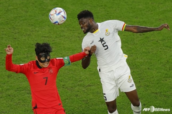 Son Heung-min (left) and Thomas Partey competing for an aerial ball during the 2022 FIFA World Cup group stage match between South Korea and Ghana. /AFPBBNews=NEWS1