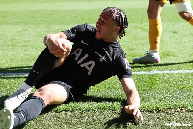 Tottenham Hotspur's number 7, Savi Simons, is shown clutching his right knee in pain. /AFPBBNews=NEWS1