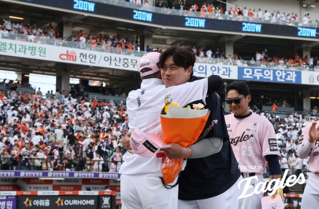 Hanwha Eagles' Ryu Hyun-jin (center) celebrates his 200th career win in Korea and the U.S. on the 24th, sharing a hug with manager Kim Kyung-moon. /Photo=Hanwha Eagles
