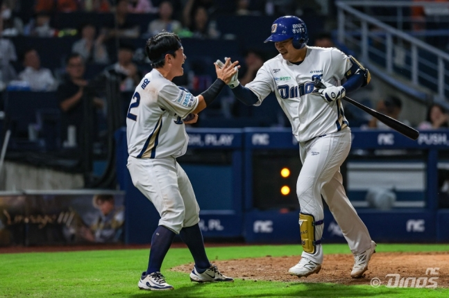 NCダイノスのクォン·ヒドン(右)が27日、昌原(チャンウォン)NCパークで行われたハンファ·イーグルスと2026新韓(シンハン)SOLKBOリーグのホーム試合で、8回裏、決勝ツーランホームランを放った後、アン·ジュンヨルとハイタッチをしている。 /写真=NCダイノス提供