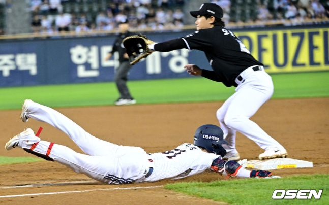 Doosan's Jo Su-haeng (below) slides head-first to reach first base safely after a surprise bunt in front of the pitcher in the bottom of the 4th inning against KT on the 27th. KT's first baseman is Oh Yun-seok. /Photo=OSEN