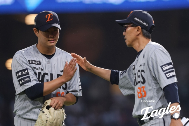 Hanwha Eagles' Park Jun-young (left) receives encouragement from coach Kim Woo-seok after starting a road game against the NC Dinos at Changwon NC Park on the 27th as part of the 2026 Shinhan SOL KBO League season, heading toward the dugout. /Photo=Hanwha Eagles
