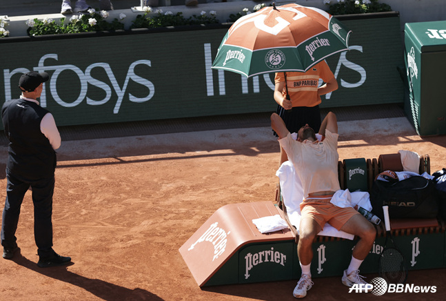 Novak Djokovic (right) struggling in the heat. /AFPBBNews=NEWS1