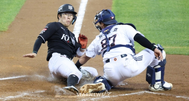 Heo Kyung-min (left) dives from second base to home plate during Kim Sang-soo's hit in the bottom of the 4th inning on the 26th, scoring the go-ahead run. The Doosan catcher is Yoon Jun-ho. /Photo=Chief correspondent Kim Jin-kyung