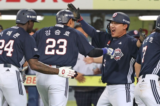 Kang Seung-ho (segundo desde la izquierda) recibe la bienvenida de sus compañeros tras conectar un jonrón con bases llenas. /Foto=Doosan Bears
