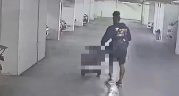 KARAvali is seen pushing a large cart containing a body in a parking lot. /Photo=The Sun archive