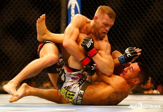 Conor McGregor (arriba) y Max Holloway se enfrentan en un combate de peso pluma del UFC el 17 de agosto de 2013 (hora de Corea). /AFPBBNews=NEWS1