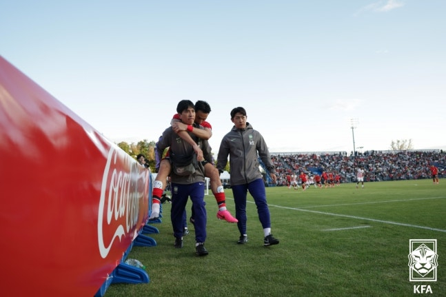 Cho Yu-min (center) being carried by staff. /Photo=Korea Football Association