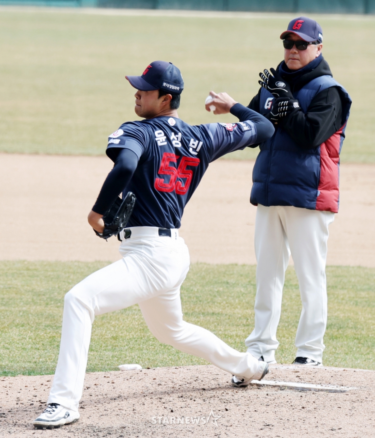 Yoon Seong-bin, lanzador diestro de Lotte, hace su aparición en el final de la sexta entrada del partido de exhibición de la 1016ª temporada de la KBO entre SSG Landers y Lotte Giants, disputado el 24 en Landers Field. Kim Sang-jin, entrenador de lanzadores, realiza una inspección. 2026.03.24. /foto=Kang Young-jo, reportero sénior