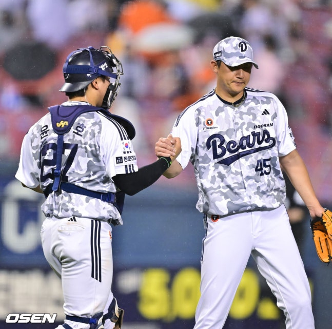 斗山（トゥサン）の李ヨンチャン（右）が4日、ハンファ戦を勝利で終えた後、捕手のユン·ジュンホと手を取り合っている。 /写真=OSEN