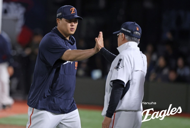 Ryu Hyun-jin của Hanwha Eagle (trái) đập tay với huấn luyện viên Kim Kyung-moon sau khi giành chiến thắng trong trận đấu giao hữu với Lotte Giants tại sân bóng chày Sajik Busan vào ngày 5. /Ảnh = Hanwha Eaglex cung cấp