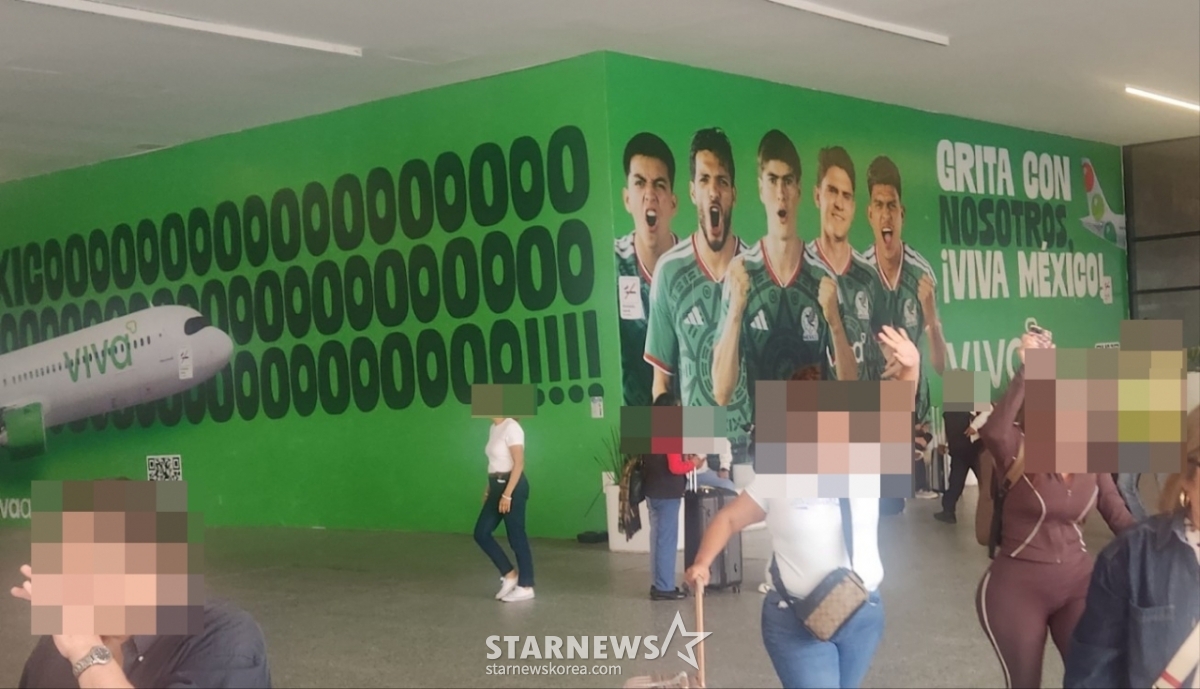 Fotografía de los jugadores de la selección mexicana de fútbol pegada en la pared del aeropuerto de Guadalajara. /Foto=reportero Park Geon-do