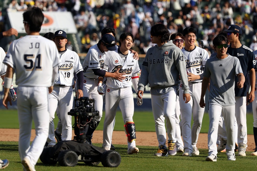 Park Jun-soon (52, en el centro) recibe los felicitaciones de sus compañeros después de conectar un hit de victoria en la parte baja del décimo inning de prórroga en el partido contra LG el 26 de abril. /Foto=Doosan Bears