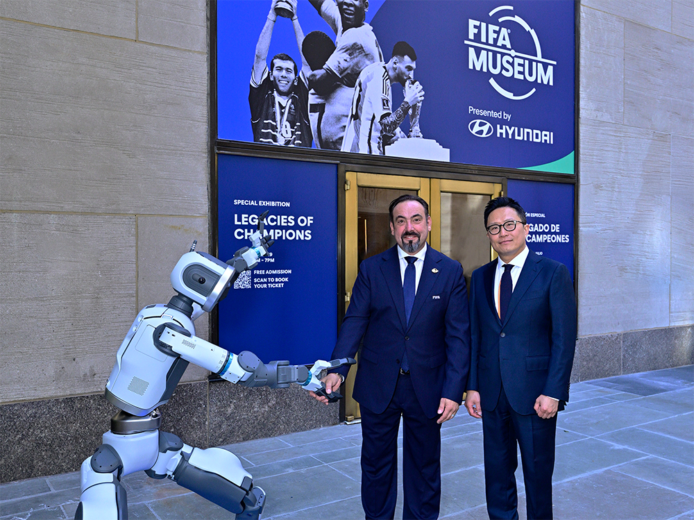 FIFA Museum Director Marco Pazzoni (left) and Hyundai Motor Vice President Ji Sung-won, Head of Brand Marketing, posing for a commemorative photo with Atlas at the entrance of the FIFA Museum. /Photo=Hyundai Motor