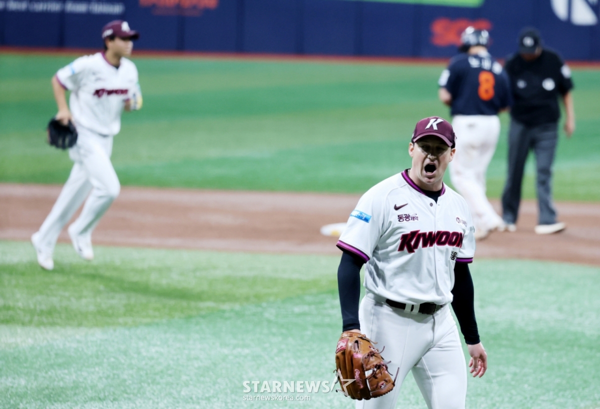 14日，"Kiwoom Heroes"肯尼•罗森伯格（右）在首尔高尺天空巨蛋体育场举行的2026新韩SOL KBO联赛韩华鹰队的主场比赛中首发出场，在第1回合初克服满垒危机，正在咆哮。 =照片=高级记者姜英祖。