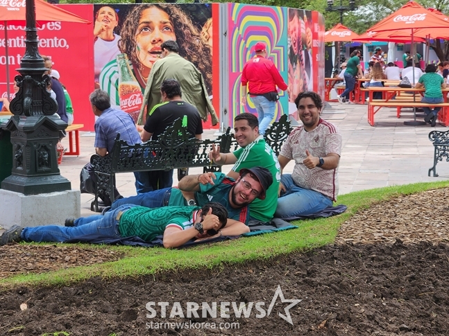 Mexicans lying on the grass and enjoying leisure time during the fan festival held at Plaza Liberacion in Guadalajara pose for the media's photo request. /Photo=Reporter Park Geon-do