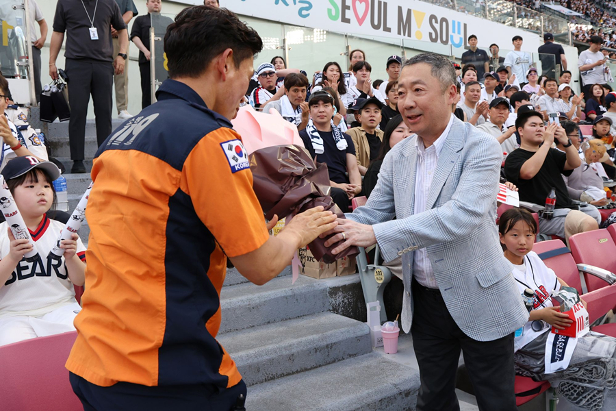 Chairman Park Jeong-won (right) is seen presenting a bouquet of flowers to Han Jeong-min (Team Lead) of the Seoul 119 Special Rescue Team on June 19, 2024, for the "Doosan Bears Fire Service Family Day." /Photo=Doosan Bears