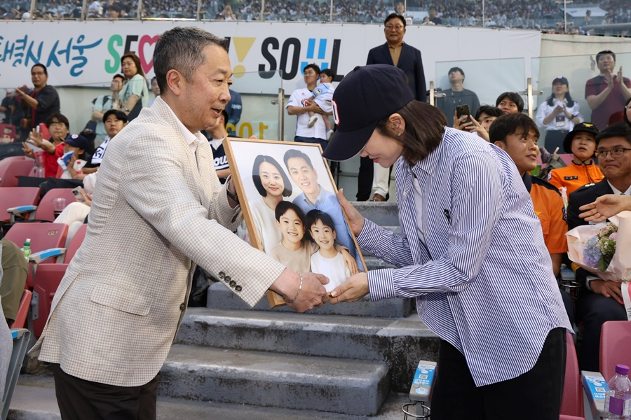 Chairman Park Jeong-won (left) is seen on June 24, 2025, at the "Doosan Bears Fire Service Family Day" event, delivering an AI-restored family photo and commemorative gifts to the family of the late Fire Chief Shim Moon-gyu, who died in the line of duty in 2018. /Photo=Doosan Bears