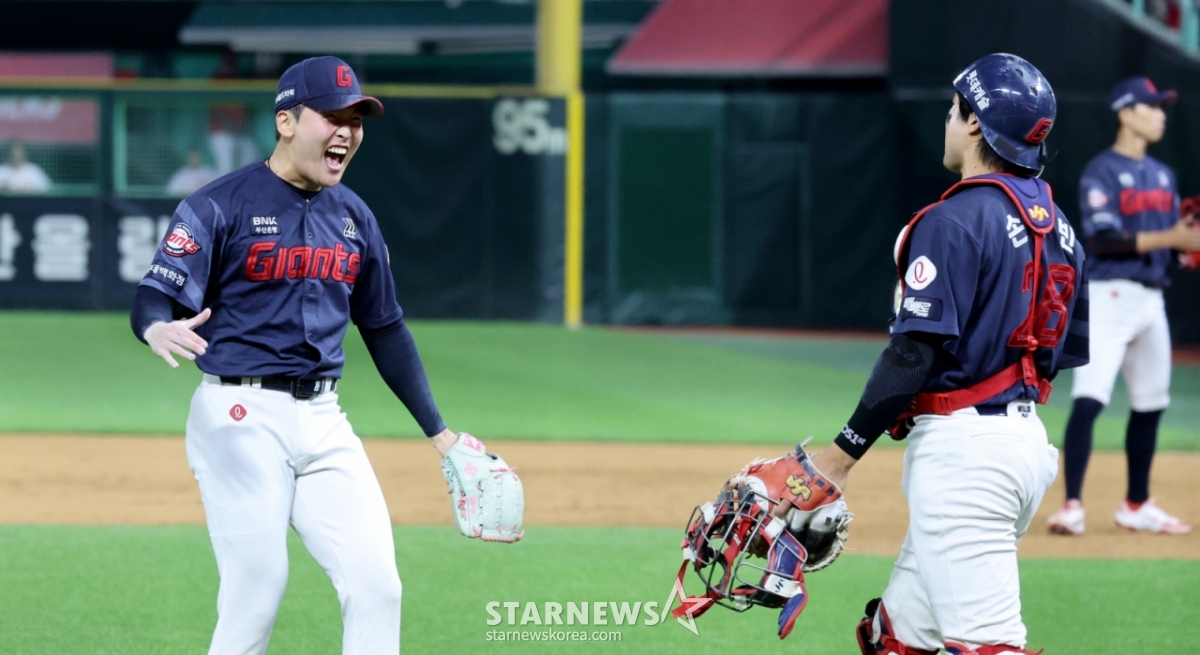 ロッテ·ジャイアンツのクローザー、チェ·ジュンヨン(左)が17日、仁川(インチョン)SSGランダースフィールドで行われたSSGランダースと2026新韓(シンハン)SOLKBOリーグ訪問試合の9回裏、1点差の勝利を守り抜き、満面の笑みで捕手のソン·ソンビンに近づいている。 /写真=姜永祚(カン·ヨンジョ)先任記者