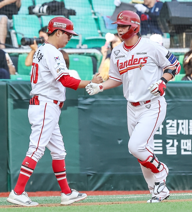SSGの崔廷(チェ·ジョン、右)が18日、ロッテ·ジャイアンツとのホーム試合で、1回裏に先制ソロ本塁打を放ち、ベースを回っている。 /写真=SSGランダース提供