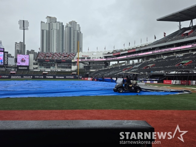 The SuwonKT Wiz Park field was prepared for the KT-KIA game scheduled for the 20th. Around 4 p.m., the tarp was removed and field maintenance began. /Photo=Reporter Kim Dong-yoon