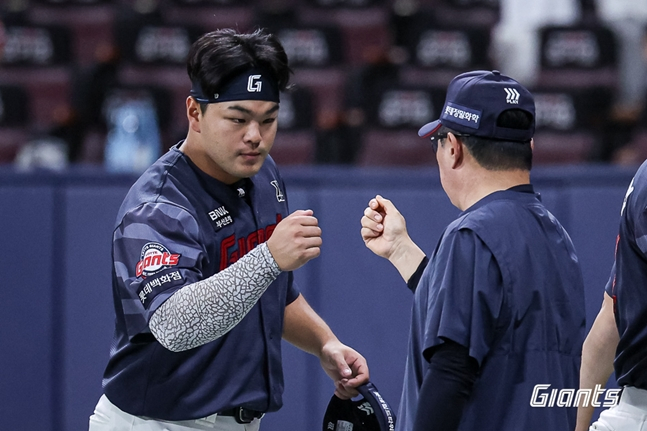 金ドンヒョン（左）とハイタッチをしている金テヒョン監督。 /写真=ロッテジャイアンツ