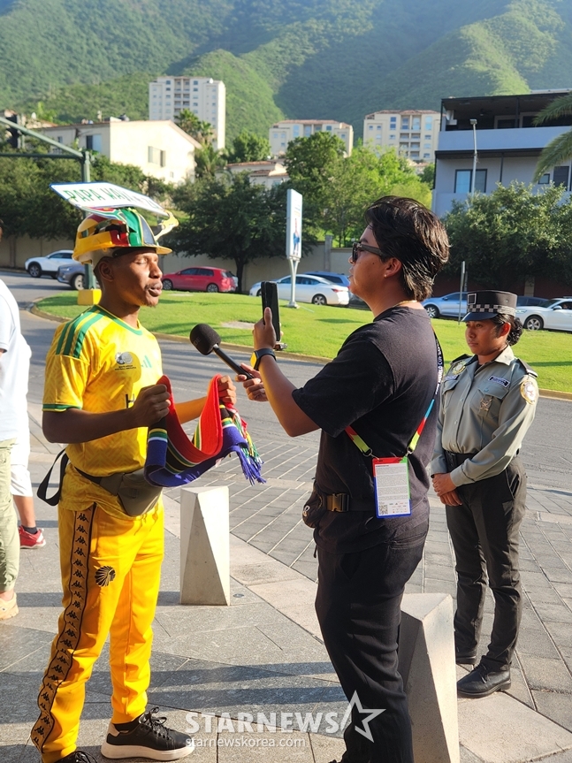 A South African media outlet interviewing a fan cheering for South Africa (left). /Photo=Reporter Park Geon-do