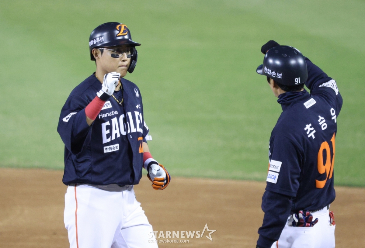 Hanwha Eagles' Chae Eun-seong (left) receives a welcome from coach Cho Seung-woo after hitting a two-run single with two outs in the bottom of the fourth inning with runners on first and second during a road game against Doosan Bears on April 3. /Photo=Chief correspondent Kim Jin-kyung