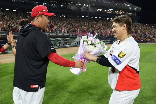 Đạo diễn Lee Bum Ho (trái) trao bó hoa cho Kim Sun Bin. /Ảnh = Kia Tigers