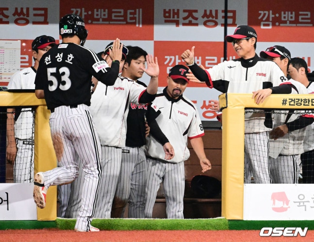 Manager Yeom Kyung-yeop gives a thumbs-up as Cheon Seong-ho (left) enters the dugout.