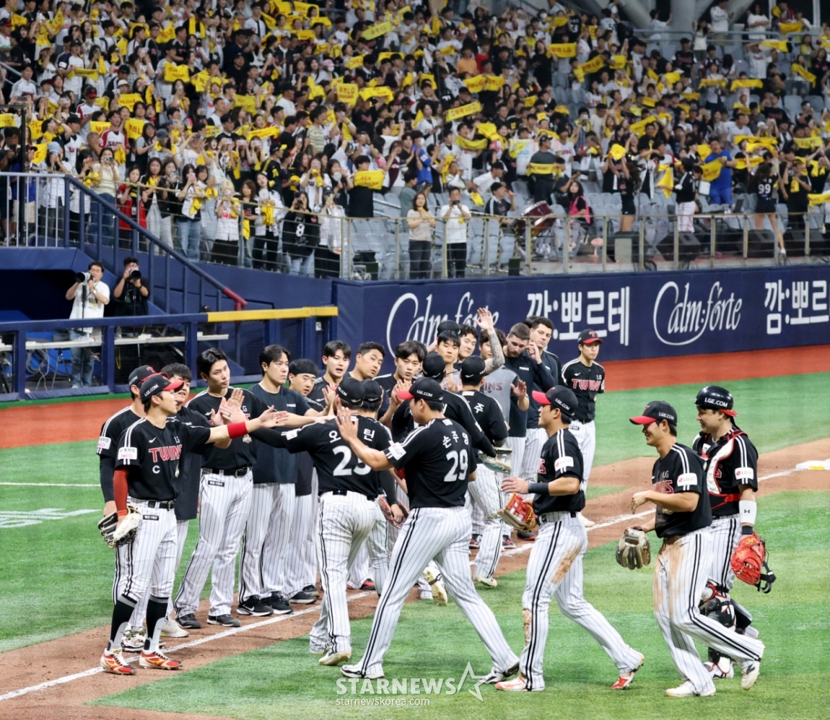 LGのヨム·ギョンヨプ監督と選手たちが1日、高尺スカイドームで開かれる2026KBOリーグのキウムヒーローズとLGツインズの試合で10-4で勝利した後、お祝いしている。 2本塁打のオースティンと代打決勝打の主人公チョン·ソンホ、抑えのソン·ジュヨンがヨム監督とハイタッチを交わしている。 2026.07.01./写真=カン·ヨンジョ cameratalks@