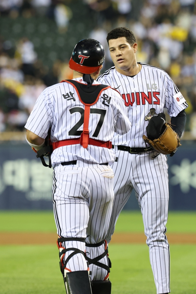 Питчер LG Twins Якселиос (справа) пожимает руку с кэтчером Пак Дон Вон после того, как в начале девятого иннинга команда вышла на поле стадиона Джамсиль против Hanwha Eagles со счетом 5-3 в 2026 году. /Фото = Предоставлено LG Twins.