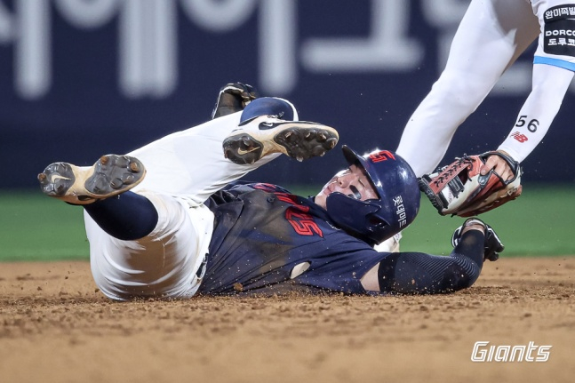 Lotte's Son Seong-bin struggles to avoid Jang Jun-won's tag during a two-out, runners on first and second situation in the game against Suwon KT on the 4th. /Photo=Provided by Lotte Giants