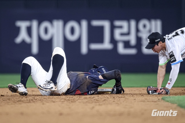 Lotte's Son Seong-bin twists his body to avoid Jang Jun-won's tag during a two-out, runners on first and second situation in the game against Suwon KT on the 4th. /Photo=Provided by Lotte Giants