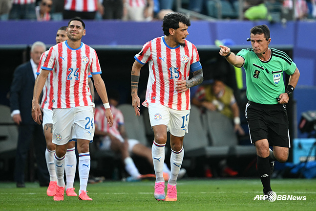 Paraguayan players and referee Djigui Tantashef (right). /AFPBBNews=NEWS1