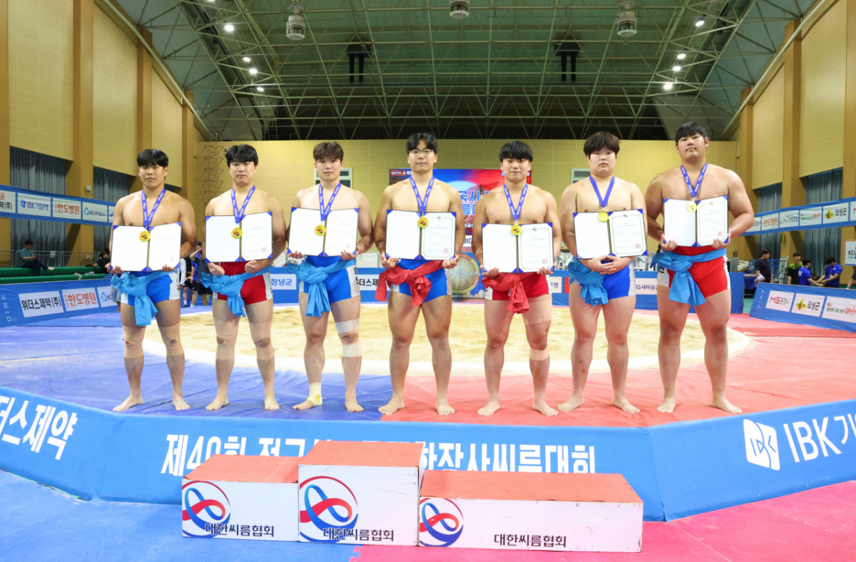 慶尚南道昌寧郡昌寧国民体育センターで開かれた第40回全国市·道対抗壮士シルム大会の大学交付個人戦で1位を占めたパク·ヒョヌ(檀国大学校)、キム·ミンゴン(檀国大学校)、ハン·ジュンモ(仁荷大学校)、アン·ユンチャン(仁荷大学校)、ヨム·テサン(翰林大学校)、チョン·ミンギュ(嶺南大学校)、イ·ジェミン(龍仁大学校)がメダルを背負って賞状を持って一緒に記念写真を撮っている。（左の順）/写真=大韓シルム協会提供