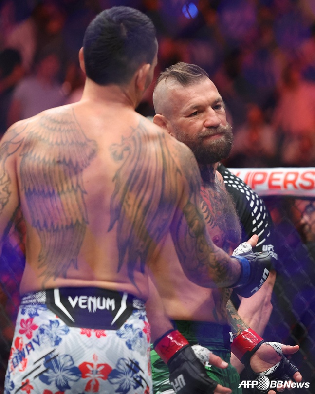 맥스 할로웨이(왼쪽)가 12일 미국 네바다주 라스베이거스 티모바일 아레나에서 열린 'UFC 329: 맥그리거 vs 할로웨이 2' 대회 메인 이벤트 웰터급 매치에서 다리 부상으로 69초 만에 TKO 패배를 당한 코너 맥그리거에게 악수를 건네고 있다. /AFPBBNews=뉴스1