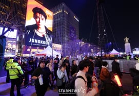 巨大电子屏幕下经过的市民们 [★照片]