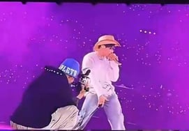 V sosteniendo la cámara directamente en el escenario / Foto: captura de tuit de cuenta de fans de BTS