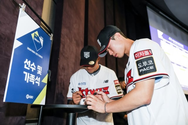 KT 위즈의 1라운드 지명을 받은 부산고 원상현(오른쪽)과 2라운드 지명자 강릉고 육청명이 9월 14일 서울특별시 중구 소공동에 위치한 웨스틴조선호텔 그랜드볼룸에서 진행된 2024 KBO 신인드래프트가 끝난 후 부모님에게 전달할 첫 기념구에 사인을 하고 있다. /사진=KT 위즈 제공