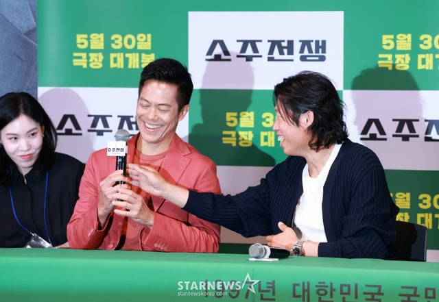 배우 유해진이 29일 오후 서울 CGV용산아이파크몰에서 진행된 영화 '소주전쟁' 언론배급시사회 및 기자간담회에서 바이런 만의 마이크를 바로잡아주고 있다.  1997년 IMF 외환위기, 소주 회사가 곧 인생인 재무이사 종록과 오로지 성과만 추구하는 글로벌 투자사 직원 인범이 대한민국 국민 소주의 운명을 걸고 맞서는 이야기 '소주전쟁'은 오는 30일 개봉한다. /2025.05.29 /사진=이동훈 photoguy@